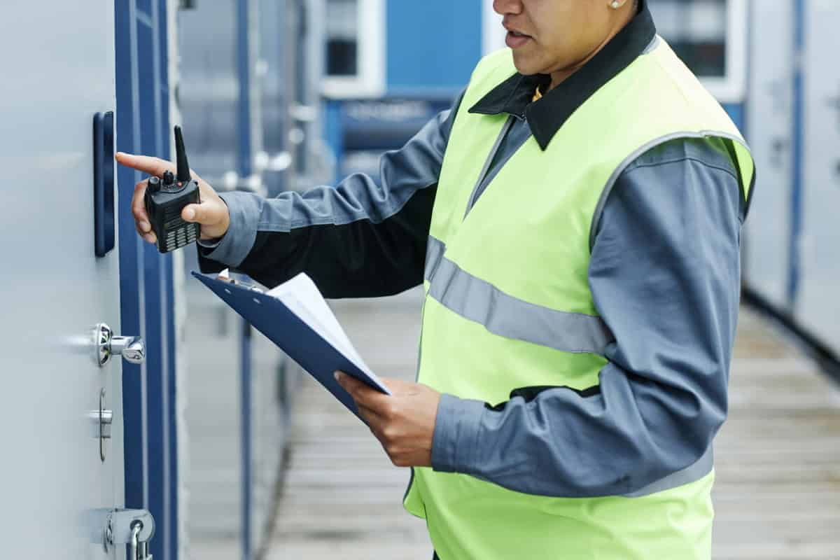 Facility Technician Inspecting Electronic Access Device And Door Hardware As Part Of Coordinated Security System Evaluation And Preventive Maintenance Planning