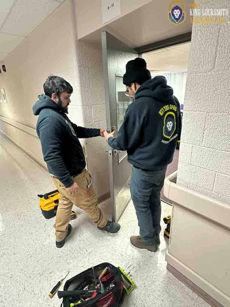 King Locksmith technicians performing commercial door lock installation and access hardware service inside Columbia MD business facility.
