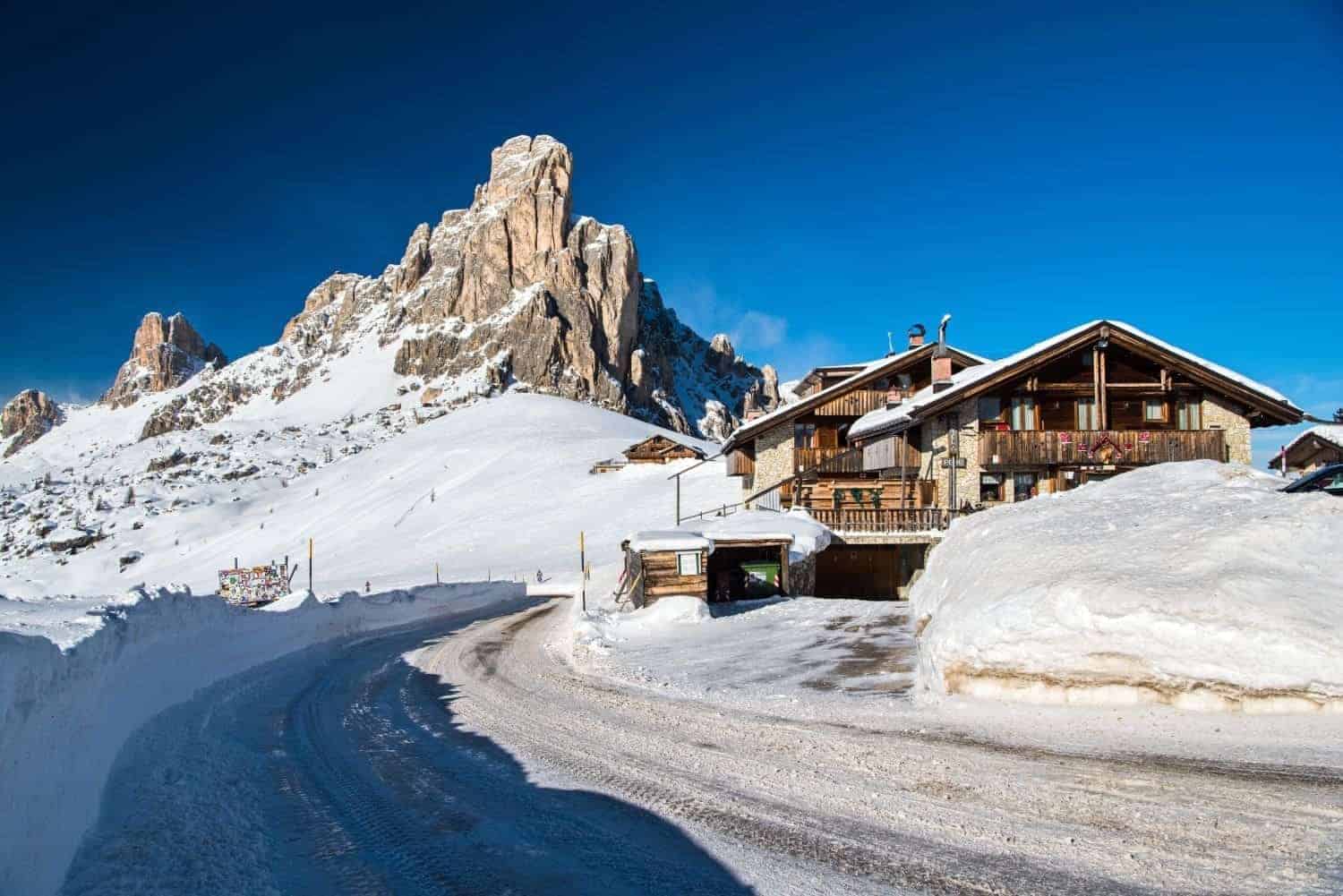 passo giau in the winter with a snowy road, snowy house, and lots and lots of snow everywhere