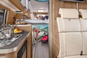 Gemütlicher Camper-Innenraum mit Schlafbereich und Küchenzeile, ideal für Camping-Urlaub.