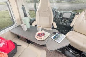 Gemütlicher Camper-Innenraum mit Esstisch und Blick nach draußen.