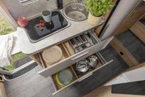 Gemütliche Küchenzeile im Moon Camper mit gut organisierten Schubladen und Kochutensilien.