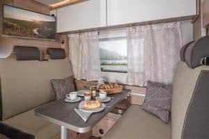 Gemütlicher Essbereich im Moon Camper mit Blick auf Natur, perfekte Ausstattung für Campingurlaub.