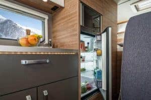 Frischer Inhalt im Mini-Kühlschrank eines Moon Camper, moderne Innenausstattung.