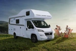 Weißer Moon Camper Wohnmobil auf Wiese mit Campinggästen am Strand, perfekte Freizeitmobilität.