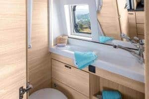 Helles Badezimmer in Moon Camper mit Holzdesign und Blick nach draußen.