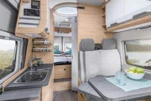 Komfortabler Wohnraum im Moon Camper mit Küche und Sitzecke.