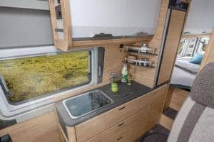 Gemütliche Küchenzeile im Moon Camper, kompakte Küche mit Fenster und Stauraum.