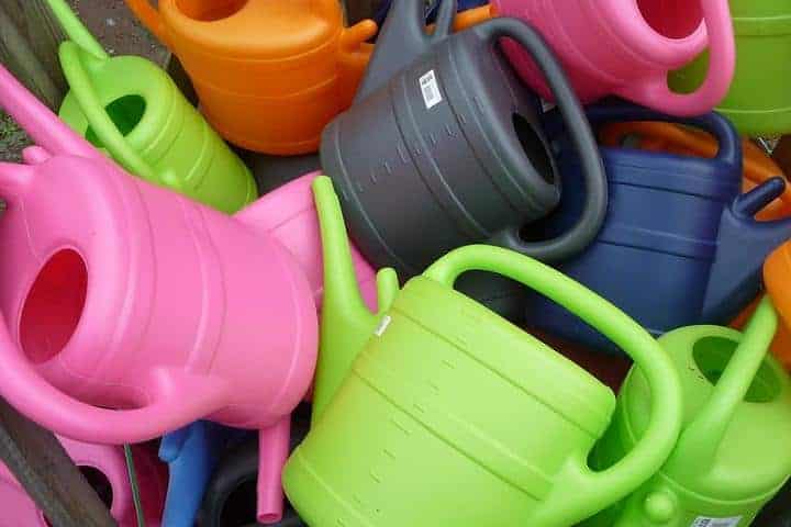 Bunte Kunststoff-Gießkannen in verschiedenen Farben für Gartenarbeit und Pflanzenpflege.