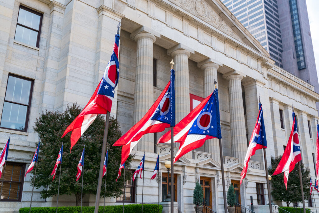 Ohio Statehouse building with Ohio flags, symbolizing Ohio Attorney General leadership change and business compliance environment