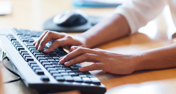close up of female hands typing on keyboard