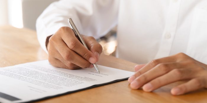 Hand of landlord, realtor pointing sign signature contract rental, purchase, buyer home or apartment with tenant, client after banker agreement mortgage, loan success or done. Property agent concept.