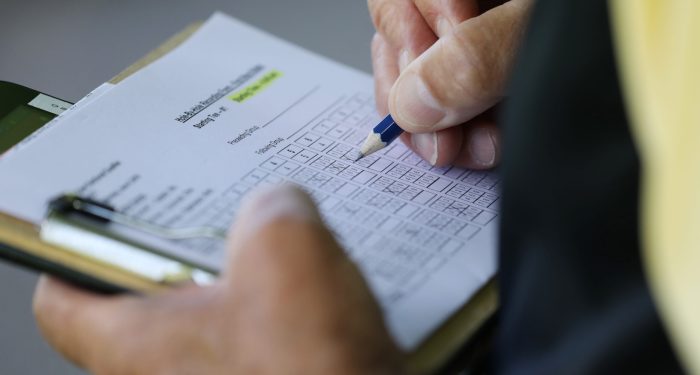 scorecard being marked with a pencil, representing the FCC's proposed robocall mitigation scorecard