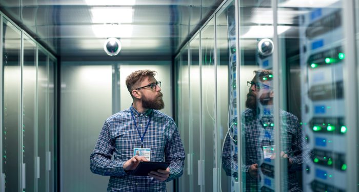 Technician reviewing server racks in a data center, representing large-scale AI infrastructure and compliance requirements under Illinois SB 315