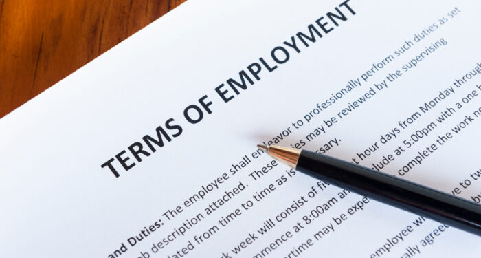 Contract outlining the terms of employment with a pen
