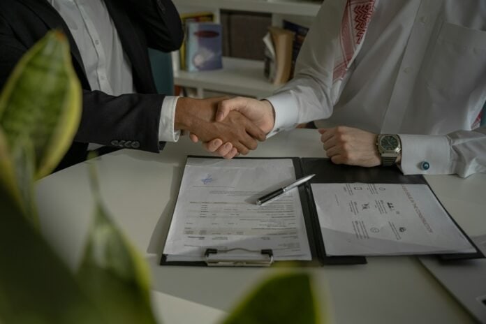 Dois executivos apertando as mãos ao fechar um contrato, representando o poder do storyselling nas negociações empresariais.