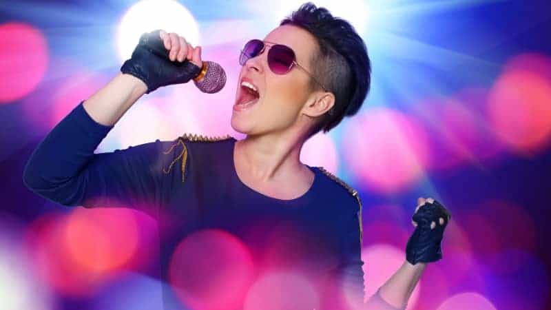 Vrolijke vrouw zingt karaoke met microfoon.