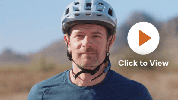Mountain bike man with helmet in a desert setting, wearing a teal shirt, with a 'Click to View' play button overlay