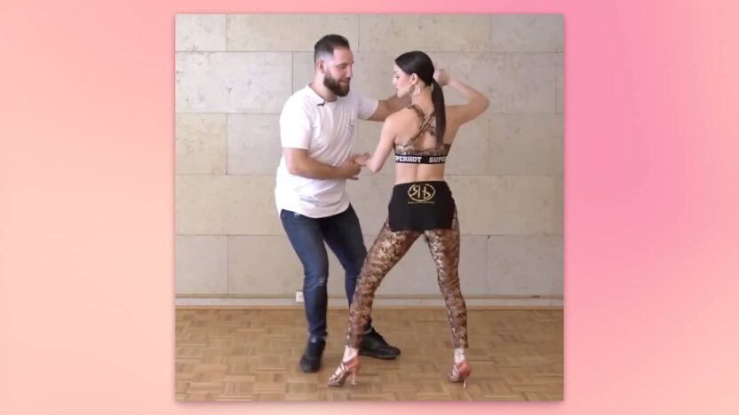 Pareja bailando bachata, realizando un giro en dos.
