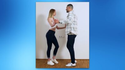 Pareja bailando bachata, realizando el paso básico adelante y atrás.