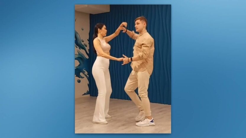 Pareja bailando bachata, realizando un lanzamiento por detrás.