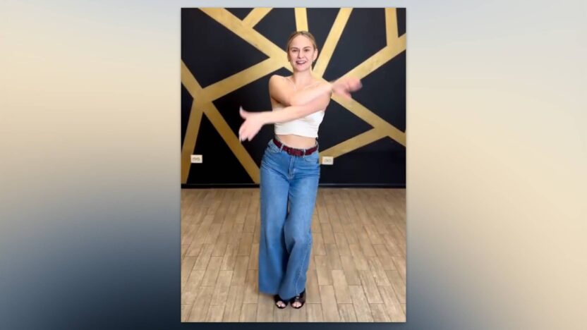 Bailarina mostrando el movimiento "mariposa" con las manos en bachata.
