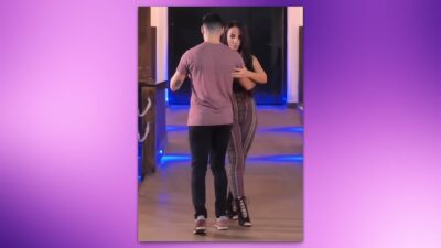 Pareja bailando Kizomba en un pasillo iluminado.