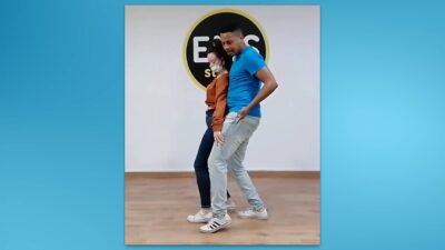 Pareja bailando bachata, mostrando el movimiento de caderas adelante y atrás.