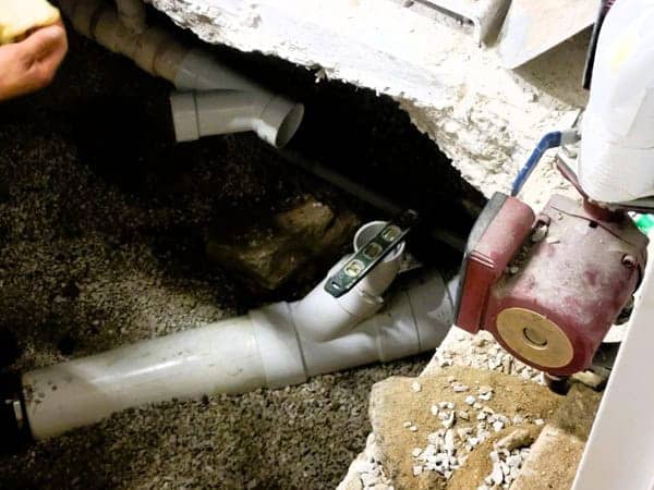 New water piping is installed under concrete flooring, surrounded by gravel, in order to repair an underground slab leak.