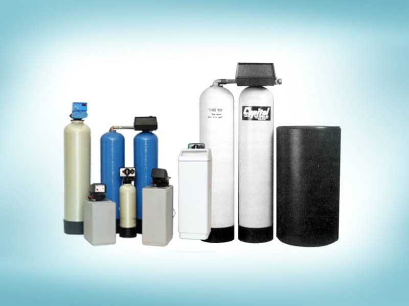 Several variations of water softeners are shown lined up in a row against a light blue backdrop.