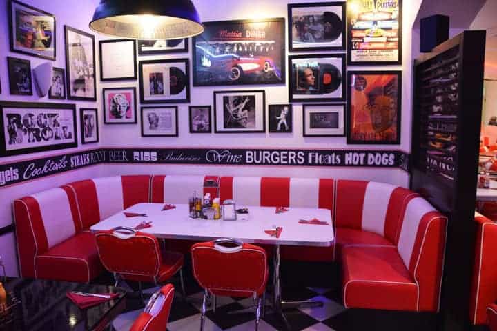 There’s nothing quite as charming as a photo gallery above the red and white striped booth of this diner wall. 