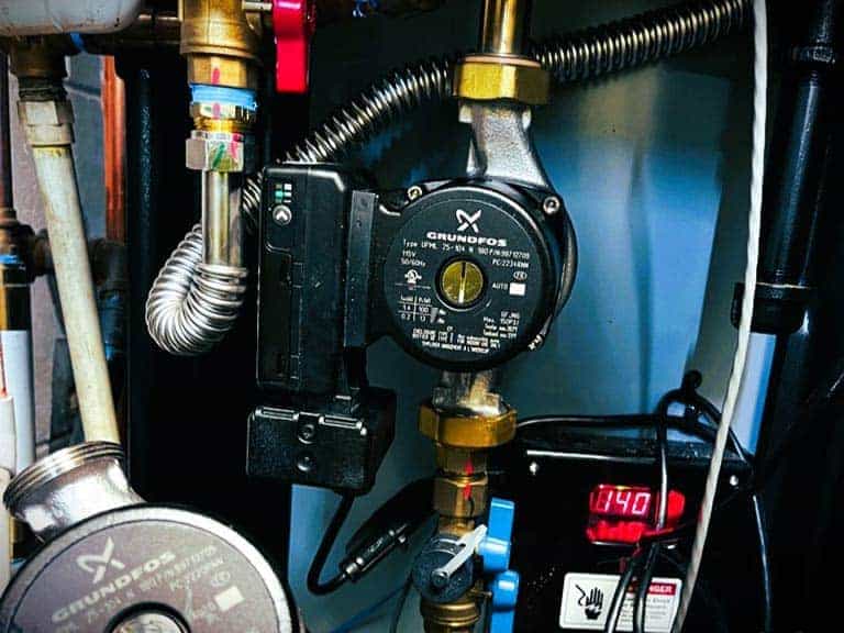 A circulation pump is shown close up amidst other water softener equipment.