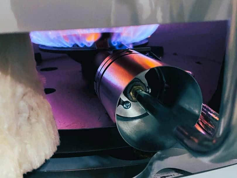 A gas pilot light is shown glowing at the base of a water heater.
