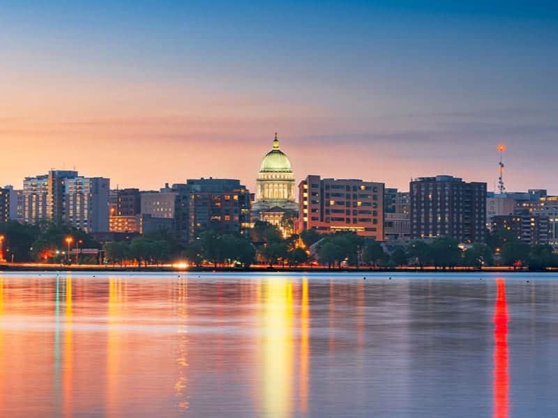 The Wisconsin State Capitol rises over the Madison skyline and Lake Monona