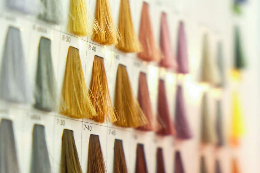 Salon hair color swatches in grey and blonde in a book.