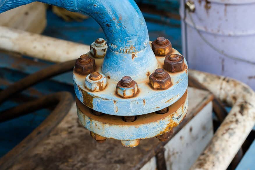 Legionella prevention in senior care includes replacing pipes like this blue joint pipe with rusty bolts. 