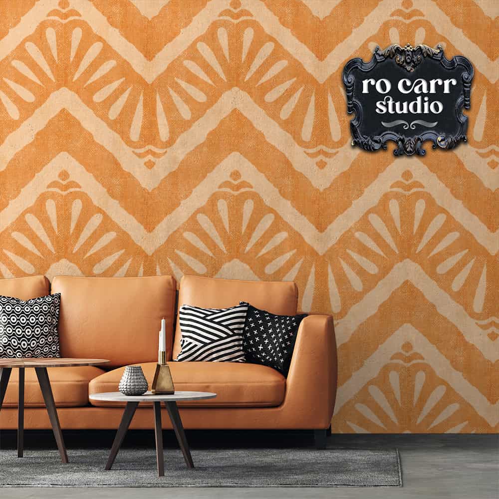 Interior living room scene with caramel colored leather couch, black and white throw pillows and a low coffee table. The feature of the image is the wallpaper behind the couch, which features the "Moroccan Zig Zag" pattern