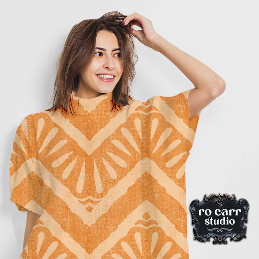 Attractive caucasian woman with shoulder length dark hair wearing a short sleeve knit poncho featuring the "Moroccan Zig Zag" pattern.