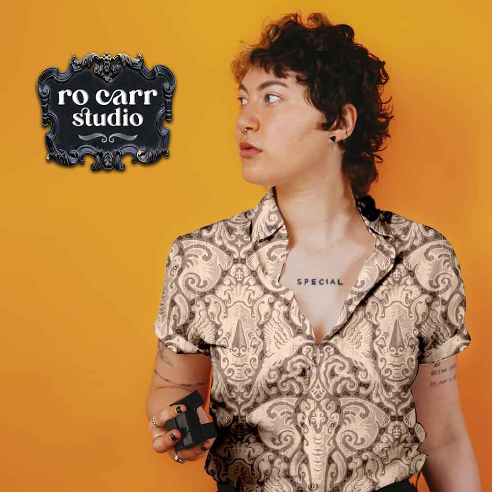 Pattern printed on a short sleeved button down shirt worn by a woman with tattoos and short curly hair.