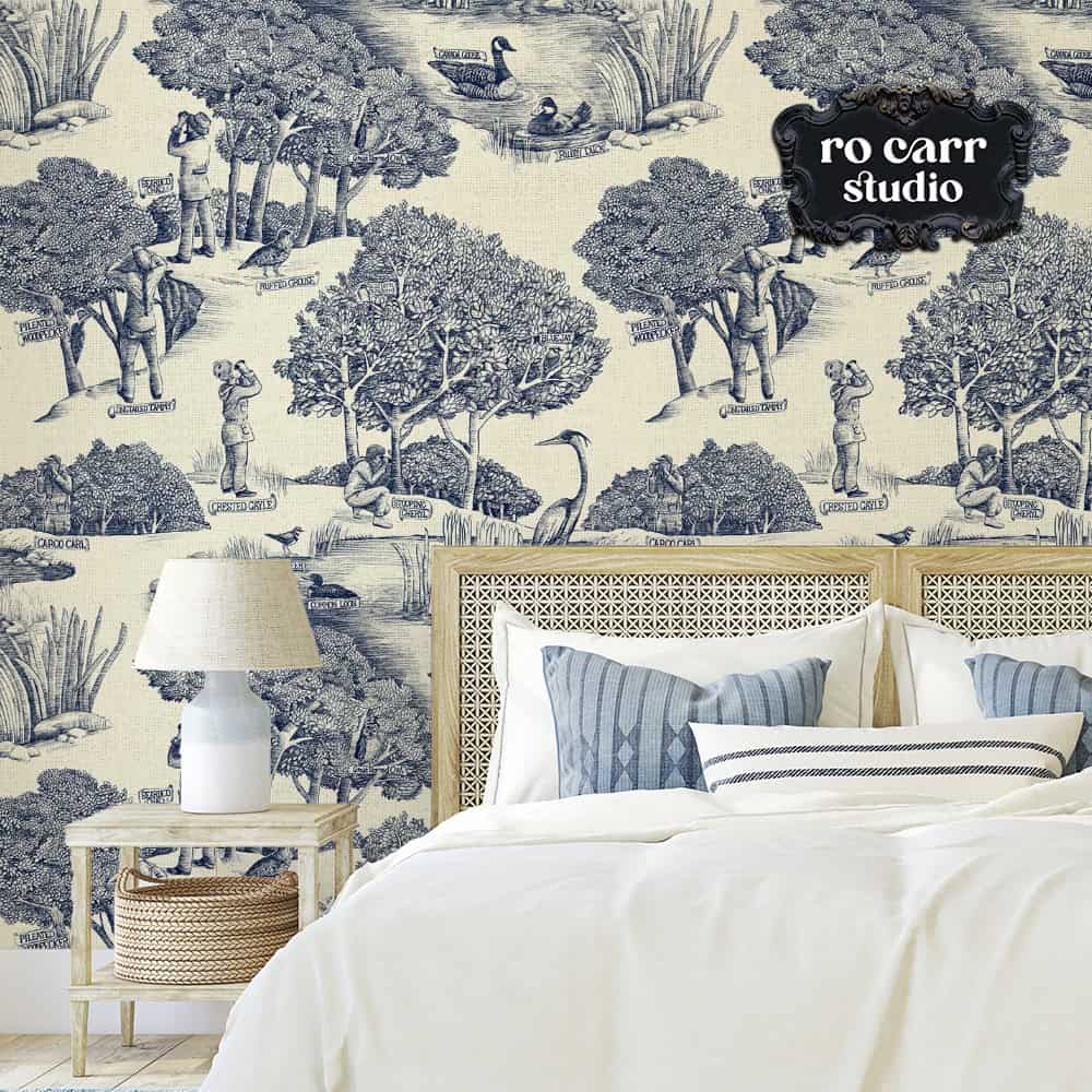 Toile de Jouy pattern with a birdwatching theme, shown in this mockup as wallpaper in a bedroom.