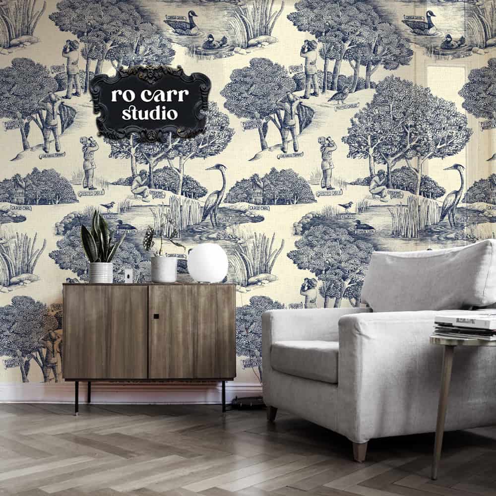 Toile de Jouy pattern with a birdwatching theme, shown in this mockup as wallpaper in a den.
