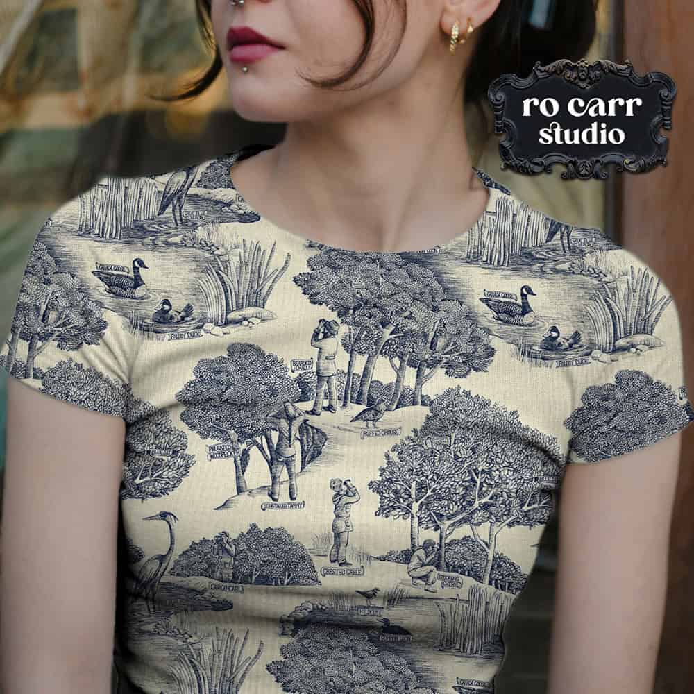 Toile de Jouy pattern with a birdwatching theme, mocked up as a fitted tee shirt worn by a young woman.