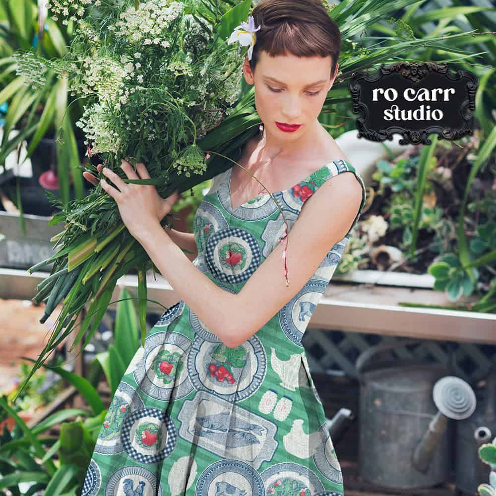 Mockup of woman working in a garden, wearing a vintage dress printed with the featured design.