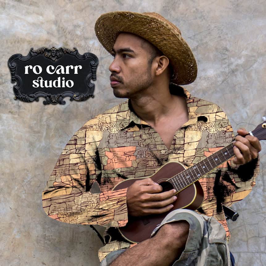 Mockup of a man in a hat playing a ukulele, wearing a long sleeved shirt printed with the Rock Candy Mountain pattern.