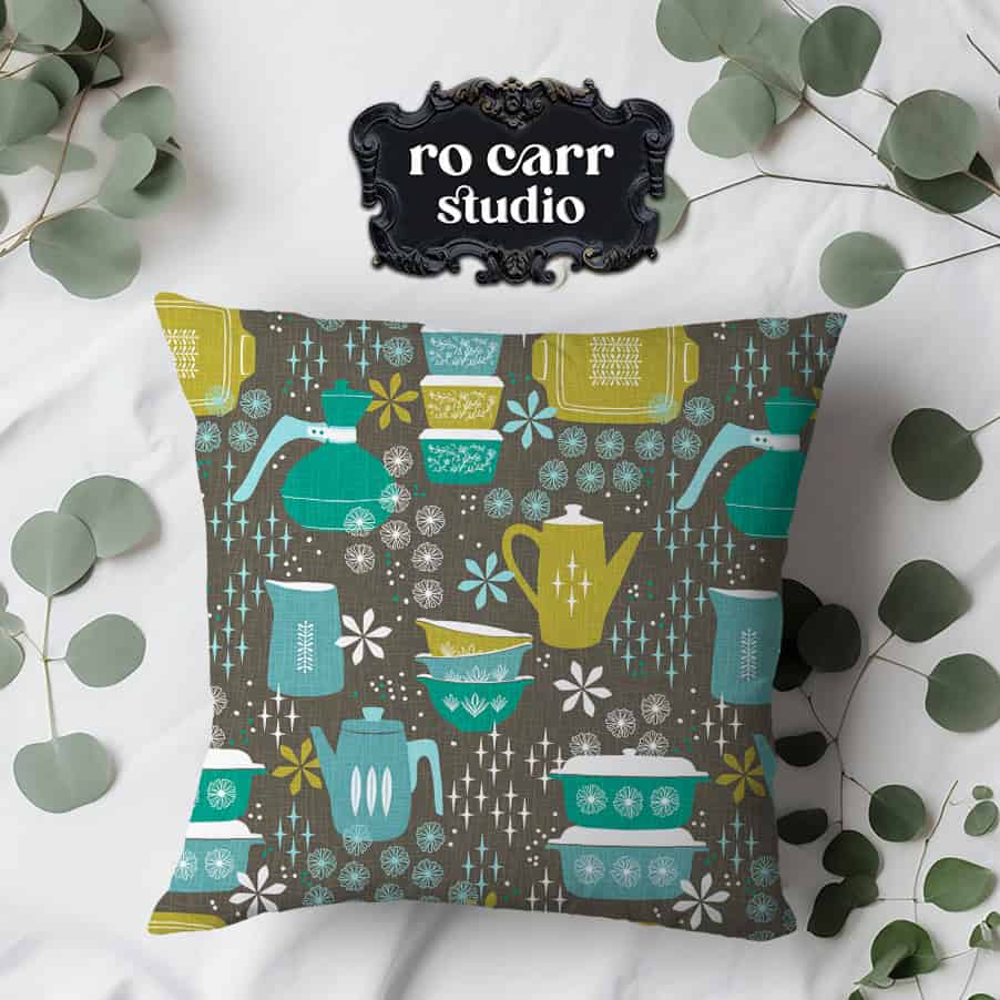 Throw pillow made of fabric printed with the pattern, shown with a surface strewn with eucalyptus leaves.