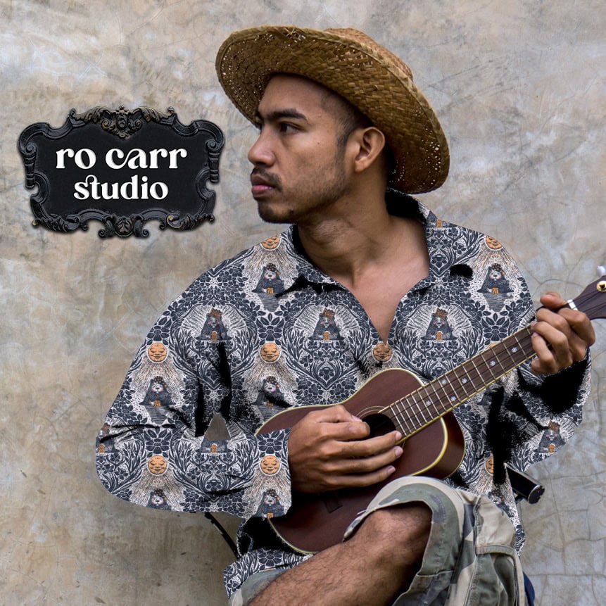 Man in a straw hat playing the ukulele, wearing a button-down shirt printed with the navy colorway.