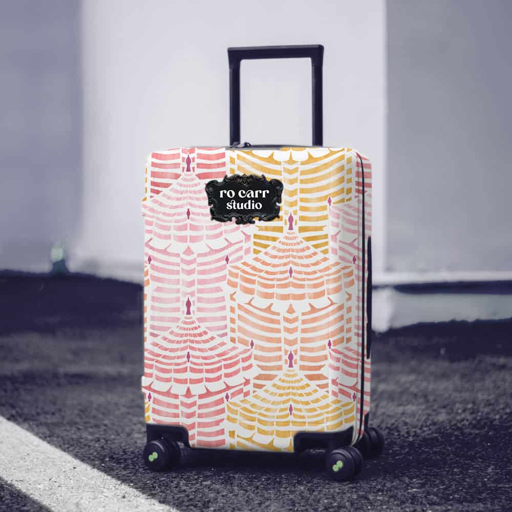 Hard-sided rolling luggage wrapped in Cabana Republic, Cotton Candy colorway, on a city street.