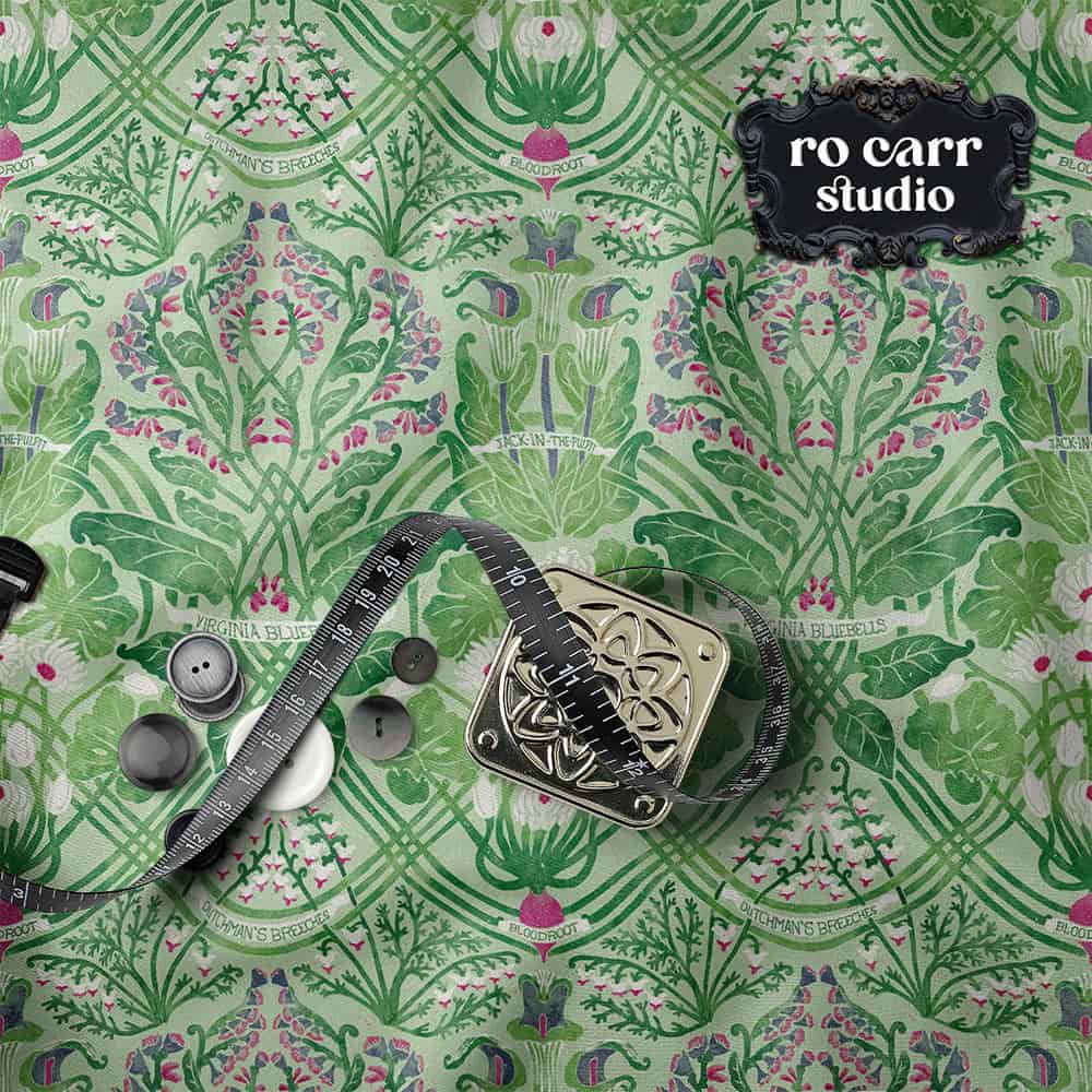 Green Art Nouveau botanical fabric swatch styled with a tape measure, buttons, and a tape measure.