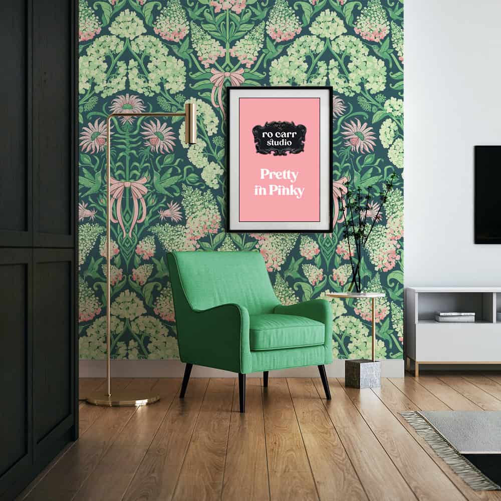 Green armchair and brass floor lamp beside a framed pink print reading "Pretty in Pinky," hydrangea damask wallpaper on the wall.