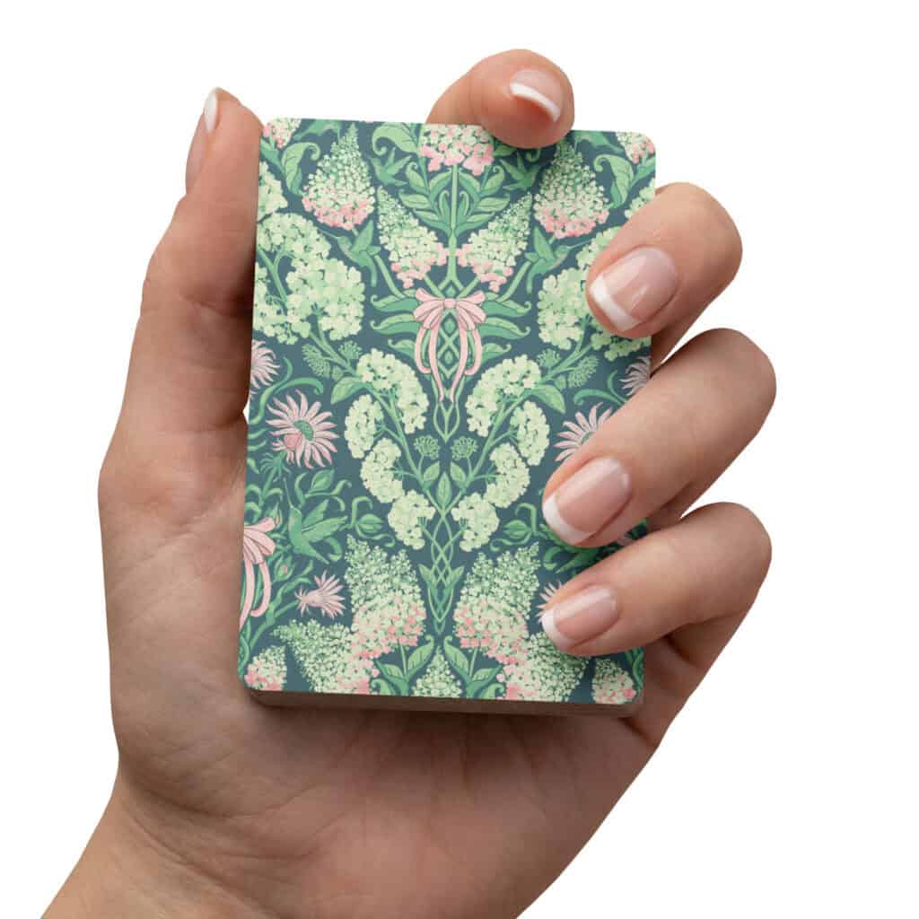 Hand holding the deck of cards, showing the print up close.